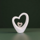 Бяла порцеланова статуетка във формата на голям контур на сърце, обгръщащо малко сърце