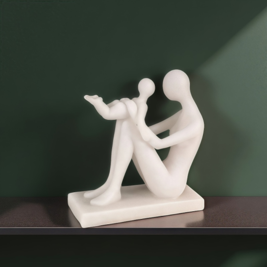 Бяла статуетка на майка, седнала на земята и вдигнала бебето си във въздуха