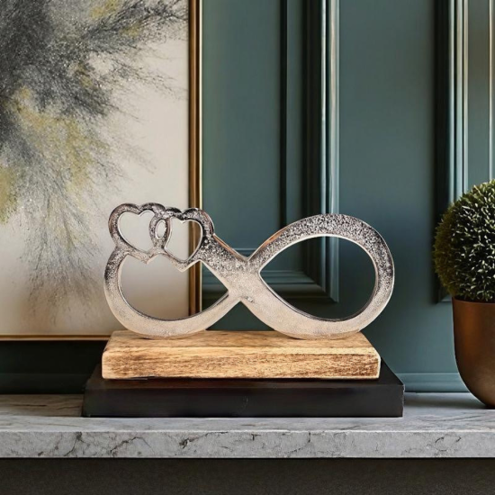 Метална статуетка във формата на знак за безкрайност с вплетени две сърца, поставена върху основа от естествено дърво