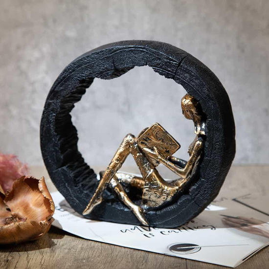 Подарък за Книгоман Абстрактна златна статуетка на жена, четяща книга, седнала в черен текстуриран кръг