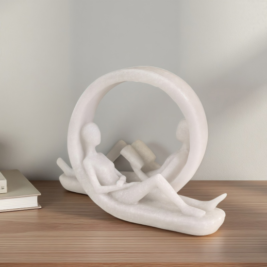 Декорация за Библиотека Бяла статуетка на двама души, четящи книги в легнало положение вътре в декоративен кръг