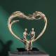 Абстрактна статуетка на влюбена двойка, седяща вътре в голяма сърцевидна арка, цвят бронз