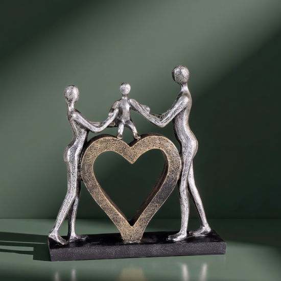 Сребриста статуетка на родители, държащи за ръце дете, което е стъпило върху голямо златно сърце