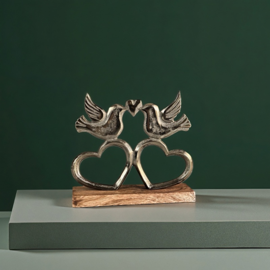 Метална статуетка на две птици, докосващи човки, образувайки сърце, поставени върху дървена основа