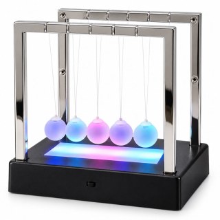 Изглед под ъгъл на кинетичната фигура, показващ многоцветното LED осветление, което прелива през матираните сфери и основата